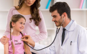 Young pediatrician examining little girl with stethoscope