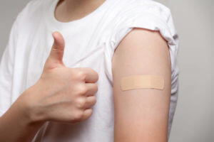 An adhesive plaster for the injection site protection glued on the hand of young boy